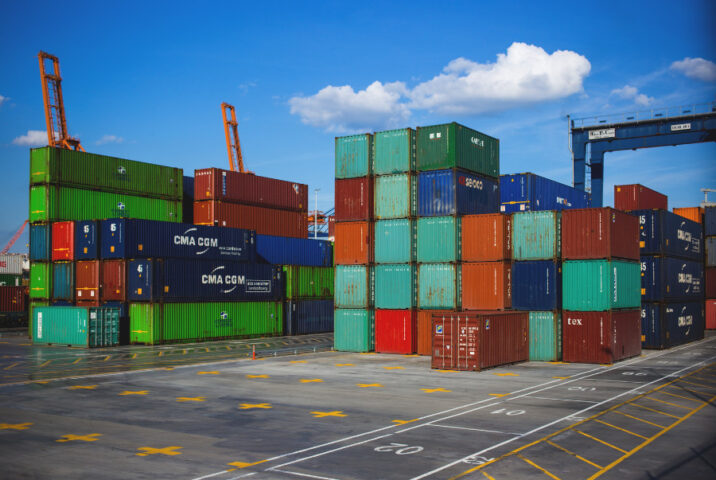 Ảnh minh họa hàng hóa được chất xếp trên container tại cảng biển, biểu tượng cho hoạt động thương mại quốc tế.