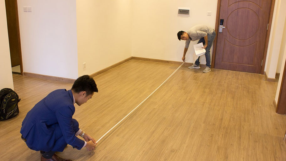 Đo chiều dài thực tế của phòng ngủ bằng thước dây