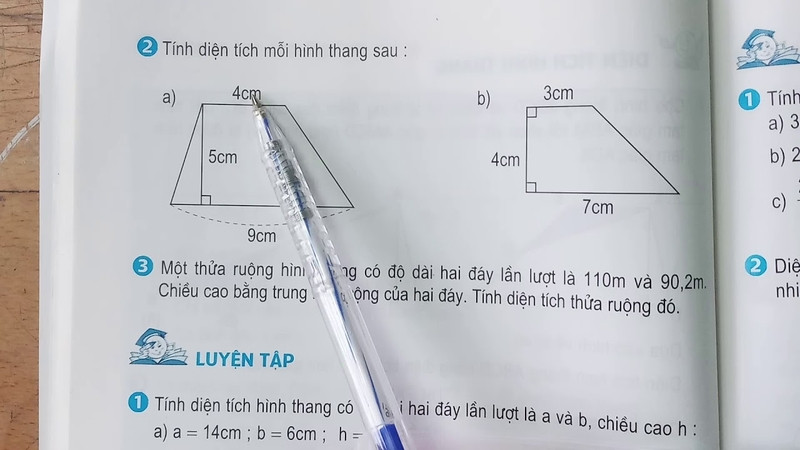 Học sinh giải bài tập tính diện tích hình thang trong sách