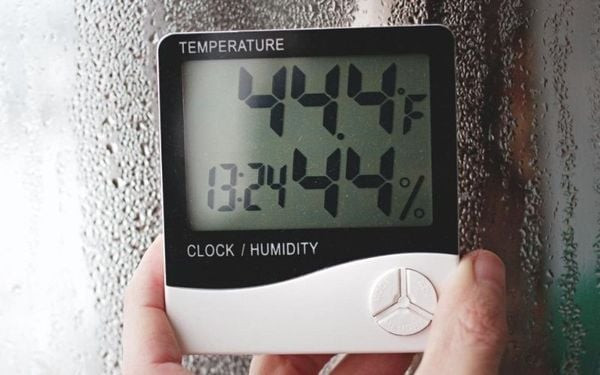 Kỹ sư kiểm tra thiết bị đo độ ẩm trong kho hàng